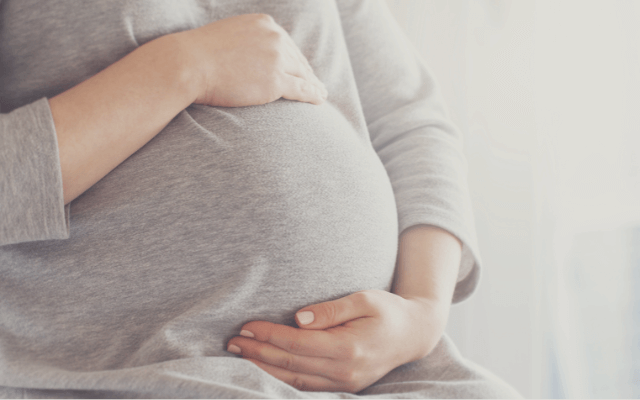 おなかを優しくさする妊婦