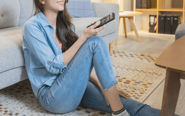帰宅後、テレビを見てまったりしている女性